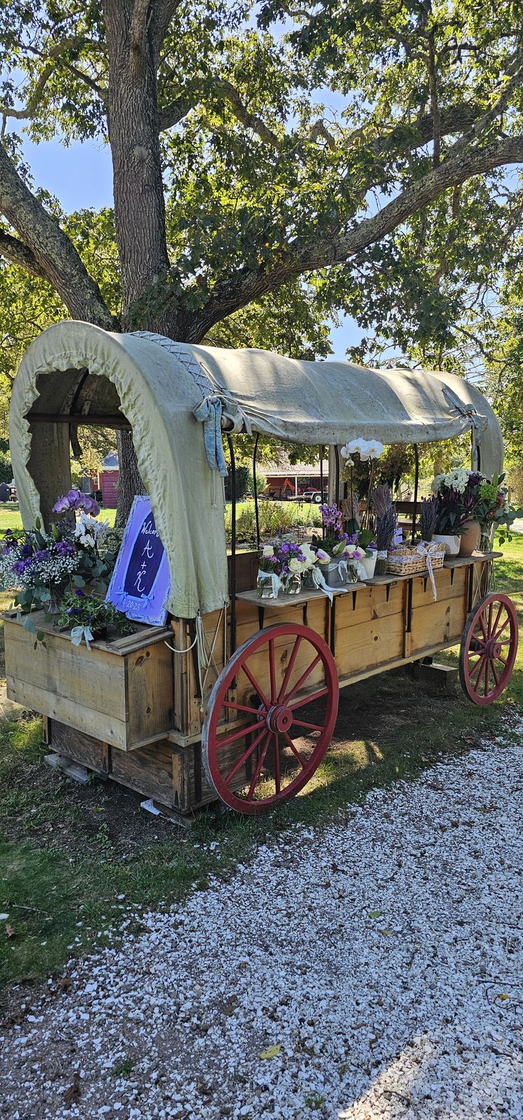 The farm's flower-covered wagon beneath the trees